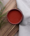 Overhead shot of an open jar of Sequoia on a wood pallet with faux greenery and a drop cloth.