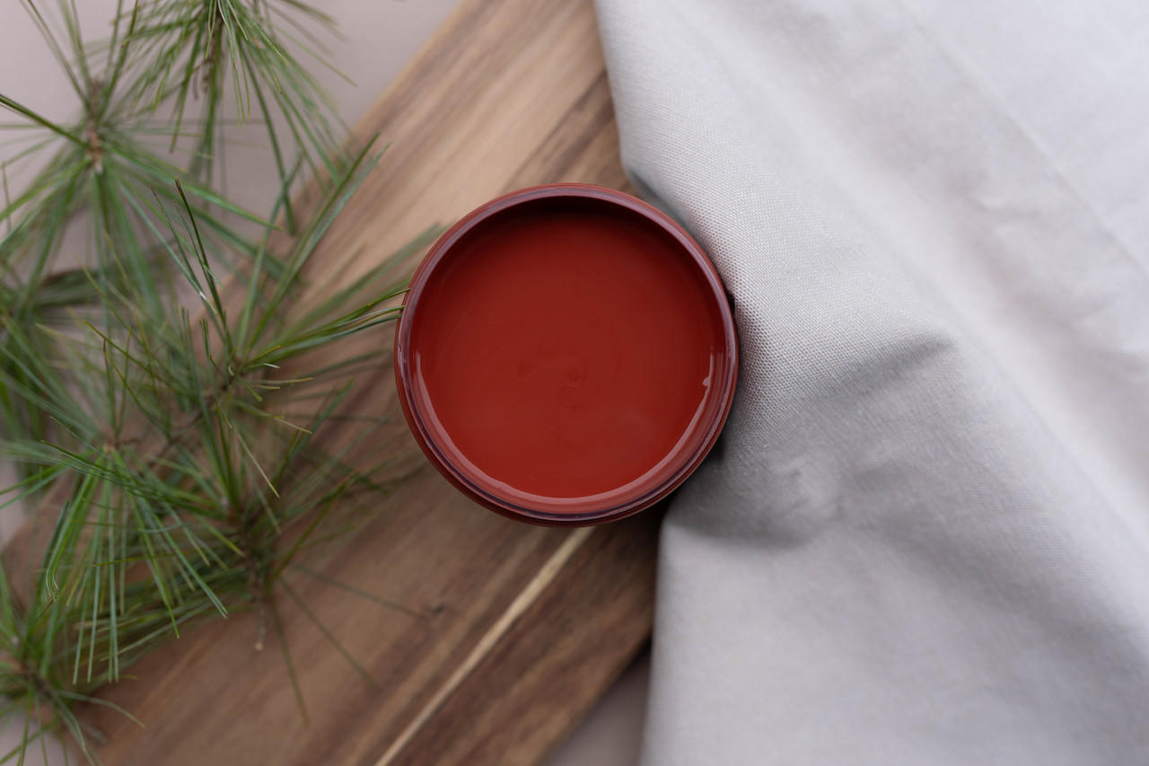 Overhead shot of an open jar of Sequoia on a wood pallet with faux greenery and a drop cloth.