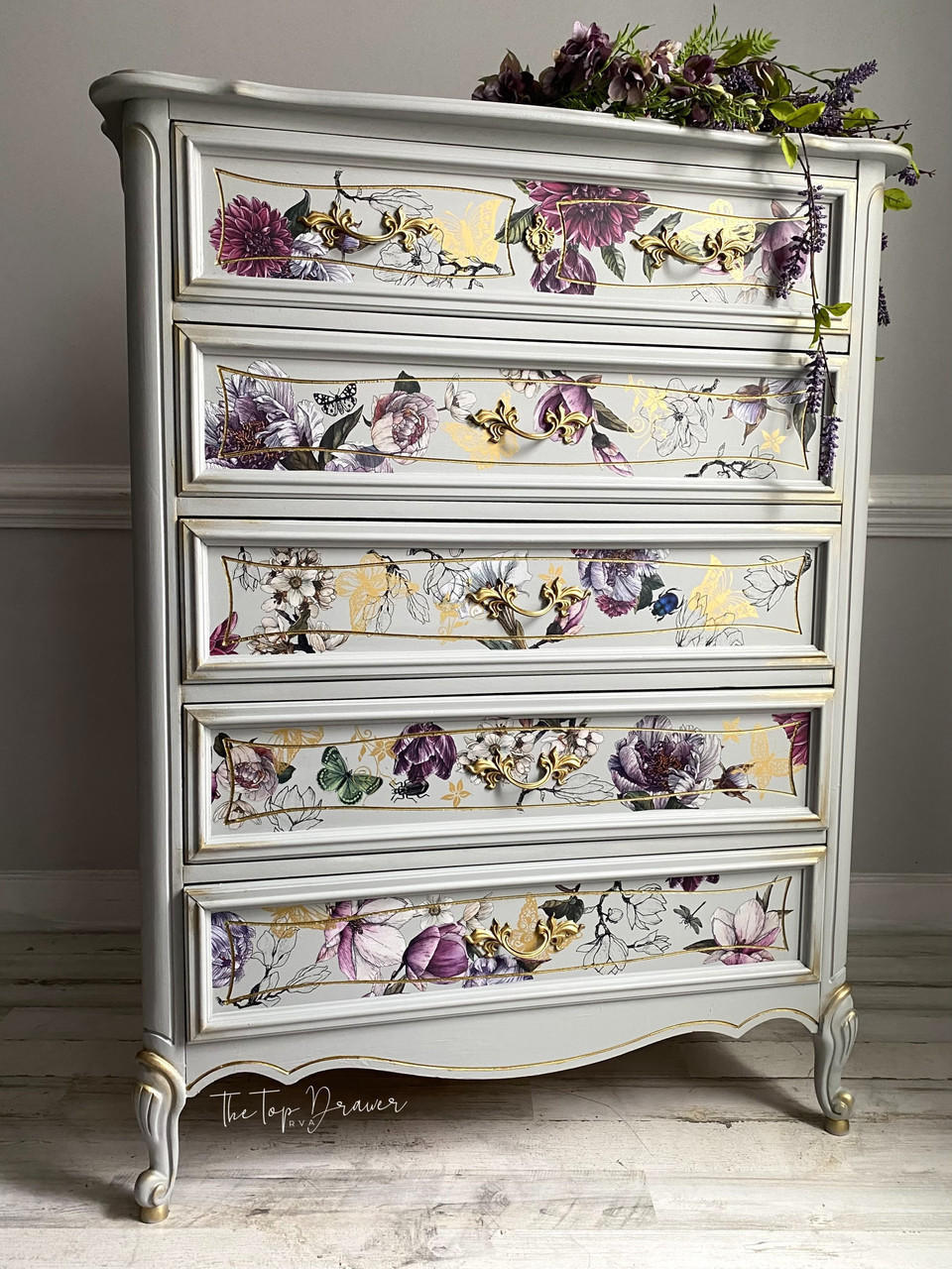 Baja Gray Silk All-In-One Mineral Paint is perfect for painting kitchen cabinets, bathroom cabinets and painting furniture. Baja Gray Silk All-In-One Mineral Paint on tall dresser. The dresser has gold accents and hardware and decorated with our Buds and Branches transfer.