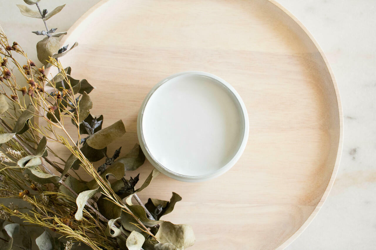 Bay Breeze Silk All-In-One paint is perfect for painting kitchen cabinets, bathroom cabinets and painting furniture. 
Image shows a top view of an opened container of  Bay Breeze Silk Paint Staged onto of shallow wooden bowl with some greenery places in the corner.