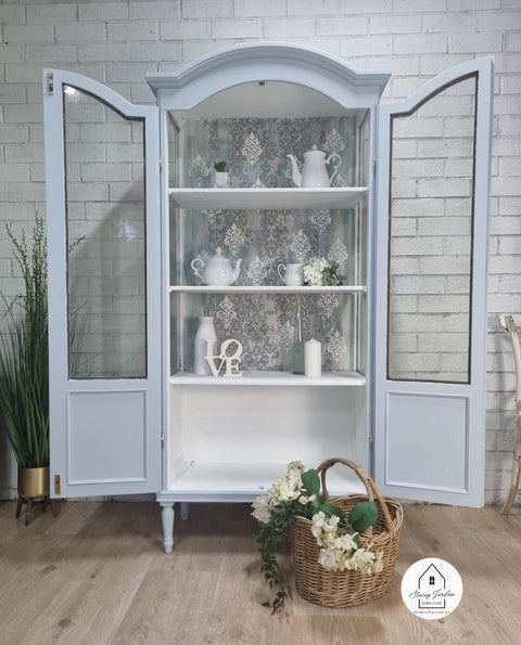 Bay Breeze Silk All-In-One paint is perfect for painting kitchen cabinets, bathroom cabinets and painting furniture.
Image of a beautiful Bay Breeze Silk Paint painted china cabinet displayed with doors wide open and tea pots with tea cups. A woven basket with white flowers is placed Infront of  piece.