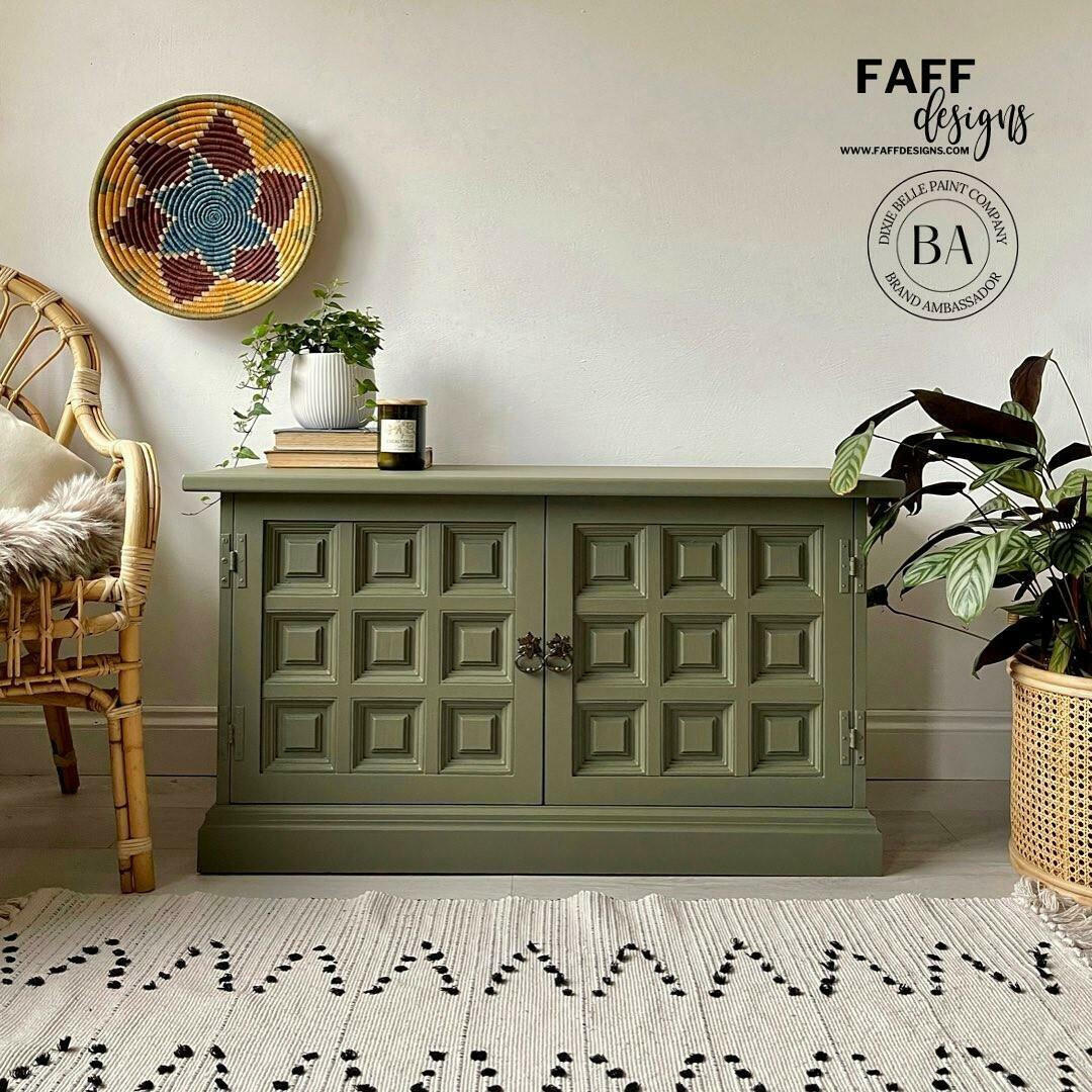 Cactus Silk All-In-One paint is perfect for painting kitchen cabinets, bathroom cabinets and painting furniture.
Entertainment center painted in Cactus Silk All-In-One paint with dark bronze hardware, staged with some greenery on and besides piece as well as books and a black candle jar on top .