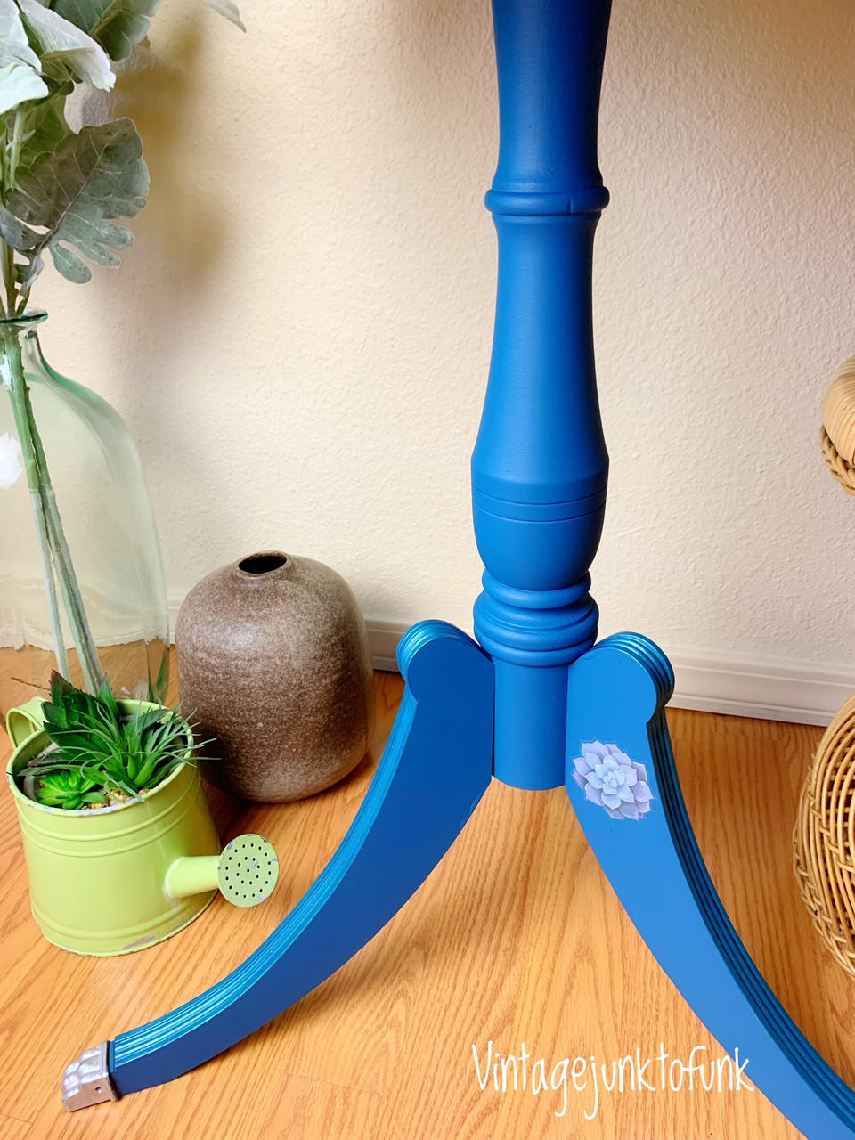 Cape Current Silk All-In-One paint is perfect for painting kitchen cabinets, bathroom cabinets and painting furniture.
The legs of a table painted in Cape Current Silk All-In-One Mineral Paint® staged with a small water can with plants and a brown small jug.