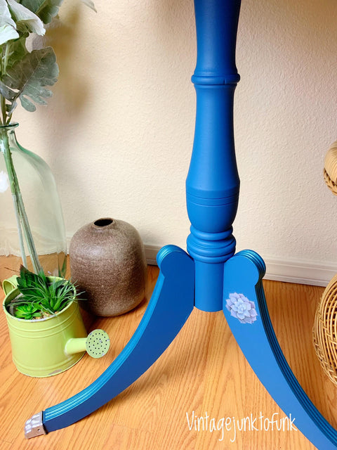 Cape Current Silk All-In-One paint is perfect for painting kitchen cabinets, bathroom cabinets and painting furniture.
The legs of a table painted in Cape Current Silk All-In-One Mineral Paint® staged with a small water can with plants and a brown small jug.