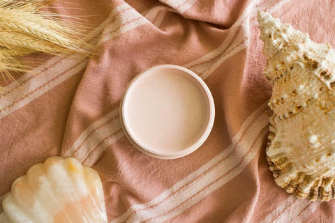 Conch Silk All-In-One paint is perfect for painting kitchen cabinets, bathroom cabinets and painting furniture
This paint is shown from the extreme angle; looking straight into the top of the paint can so all you see is the Conch CMP.  It is a white paint that has a slight peach tint.  The can is sitting on a peach towel with white strips.  laying around the paint is an ornate Conch shell, another shell that is white and peach. There is also a sprig of wheat in the upper left corner of the picture frame.