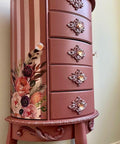Desert Rose Silk All-In-One paint is perfect for painting kitchen cabinets, bathroom cabinets and painting furniture
Here is a large, tall, 5 drawered, three-legged jewelry piece of furniture.  It is painted in Desert Rose CMP.  There are appliques on the bottom of the furniture and Decoupage on side of the piece.  The side is painted in stripes with Desert Rose alternating with Soft Pink CMP.  This piece of furniture is up against a light green wall.