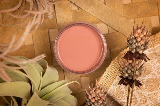 Desert Rose Silk All-In-One paint is perfect for painting kitchen cabinets, bathroom cabinets and painting furniture
This is a picture of the Desert Rose Silk All-In-One paint taken looking directly down on the paint.  Around the paint container are dried leaves and flowers.  It all rests on a wicker mate.  There is a piece of burlap under a dried flower.  The burlap has some white stenciling on top.