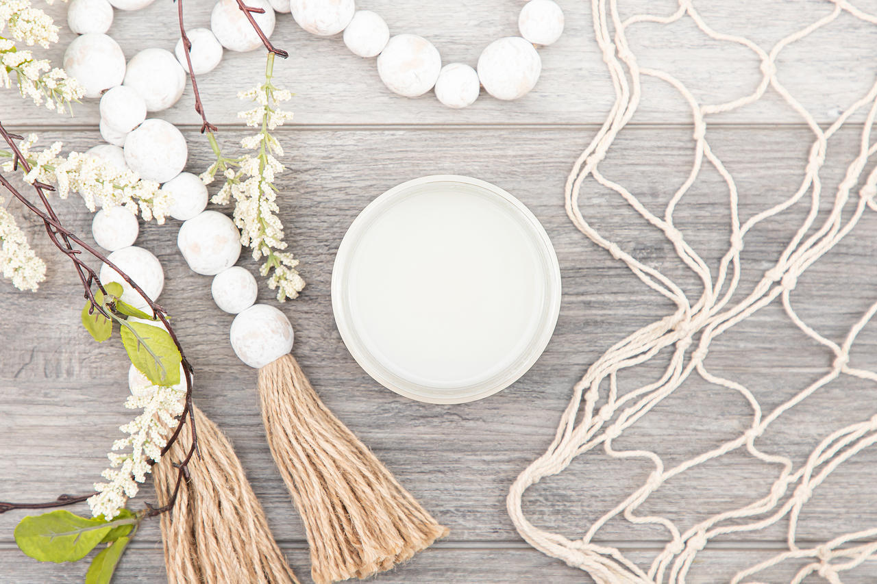 Silk All-In-One Mineral Paint Extra Coat. Open jar of Extra Coat next to faux greenery, wooden beads with yarn on the ends, and a fabric net placed around it.