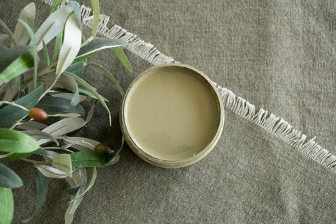 Hampton Olive Silk All-In-One paint is perfect for painting kitchen cabinets, bathroom cabinets and painting furniture.
Opened container of the Hampton Olive Silk All-In-One paint with a mute green linen and greenery .
