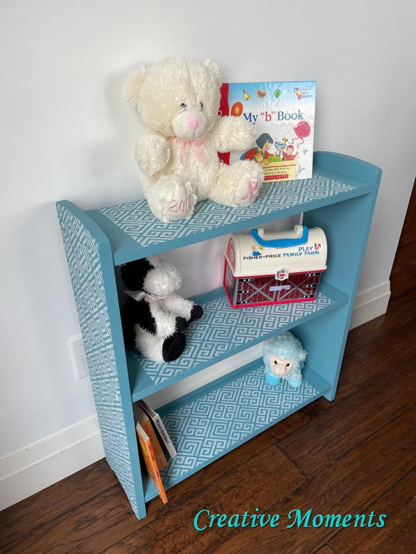 Harbor Silk All-In-One paint is perfect for painting kitchen cabinets, bathroom cabinets and painting furniture.
Bookshelf painted in Harbor Silk All-In-One paint along with Greek Key - Stencil with white paint on each shelf and on the side panels. Staged with children books, stuffed animals and a toy. A white wall is behind the piece and wood floors.