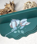 Midnight Green Silk All-In-One paint is perfect for painting kitchen cabinets, bathroom cabinets and painting furniture. Dark green wall Shelf with Floral Rub on transfer. Staged with a wicker ball and a dried up plant.