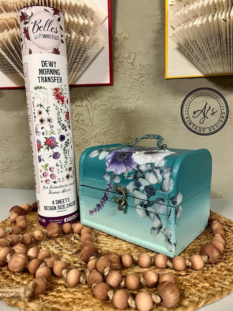 Mirage Silk All-In-One paint is perfect for painting kitchen cabinets, bathroom cabinets and painting furniture. Blue Green Silk All-In-One paint Ombre case with floral rub on transfers. Staged next to a tube of Belles and whistles Dewy Morning transfers, sitting on top of a wicker plate holder and wood beads wrapped around.