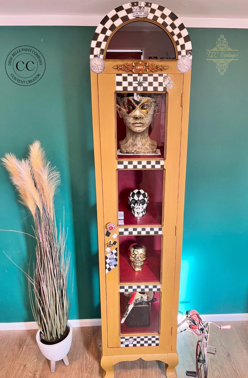 Mojave Silk All-In-One paint is perfect for painting kitchen cabinets, bathroom cabinets and painting furniture. Yellow Silk Painted Display cabinet with black and white checkered and rub on clock transfers. Staged with Skulls and a mannequin head with mask on and a pot with wheat on it and a small bicycle.