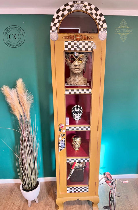 Mojave Silk All-In-One paint is perfect for painting kitchen cabinets, bathroom cabinets and painting furniture. Yellow Silk Painted Display cabinet with black and white checkered and rub on clock transfers. Staged with Skulls and a mannequin head with mask on and a pot with wheat on it and a small bicycle.