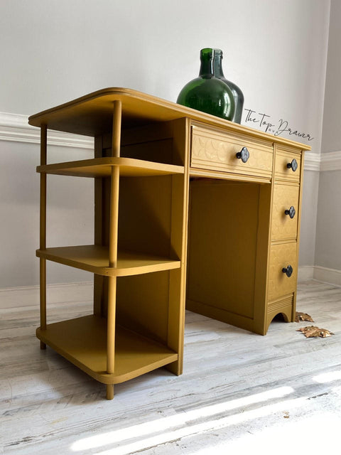 Mojave Silk All-In-One paint is perfect for painting kitchen cabinets, bathroom cabinets and painting furniture. Yellow Silk painted desk with black hardware and staged with a green glass vase.