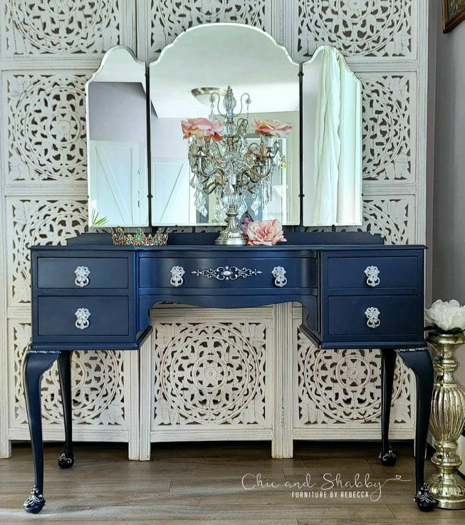 Nautical Silk All-In-One paint is perfect for painting kitchen cabinets, bathroom cabinets and painting furniture. Dark blue chalk painted vanity with white hardware. Staged with a chandelier, roses, and a tiara.