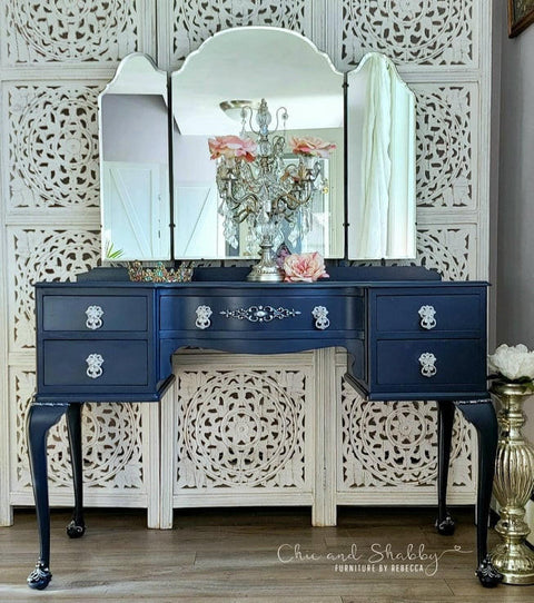 Nautical Silk All-In-One paint is perfect for painting kitchen cabinets, bathroom cabinets and painting furniture. Dark blue chalk painted vanity with white hardware. Staged with a chandelier, roses, and a tiara.