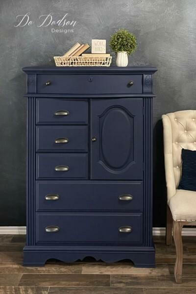 Nautical Silk All-In-One paint that is perfect for painting kitchen cabinets, bathroom cabinets and painting furniture. Dark blue painted dresser with gold hard ware. Staged with plants and wicker basket of books.