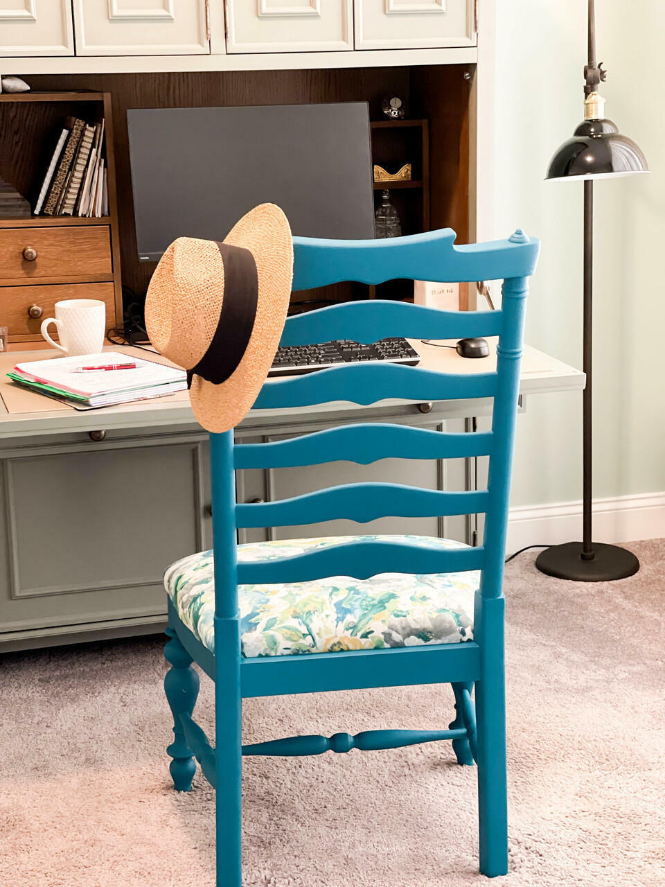 Oasis Silk All-In-One paint is perfect for painting kitchen cabinets, bathroom cabinets and painting furniture. Blue chalk painted chair with floral fabric on the seat. Staged in front of a desk with a hat on the top of chair.