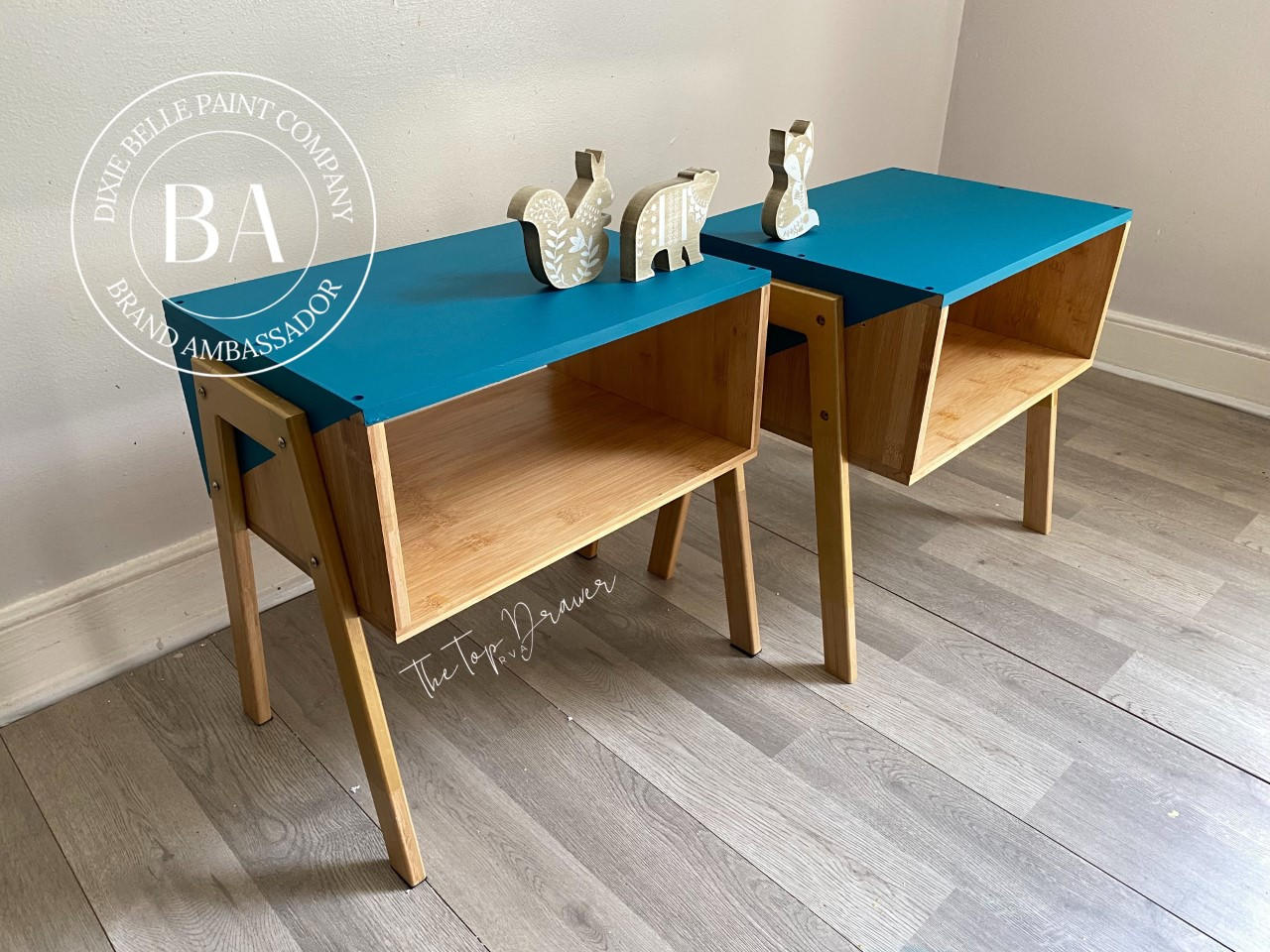 Oasis Silk All-In-One paint is perfect for painting kitchen cabinets, bathroom cabinets and painting furniture. Two end tables with the tops chalk painted blue. and the bottoms stained natural wood color. Staged with woodland figures.