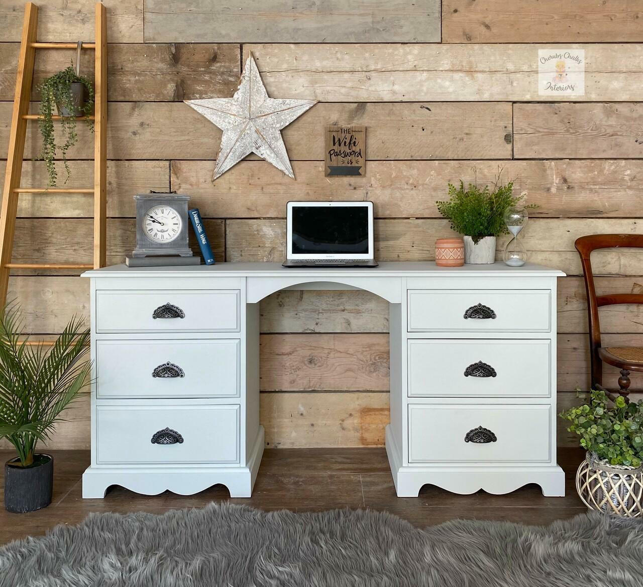 Oyster Silk All-In-One paint is perfect for painting kitchen cabinets, bathroom cabinets and painting furniture. White  Silk All-In-One painted desk with Silver hardware. Staged with plants, a computer, desk clock, blanket ladder, and plants.