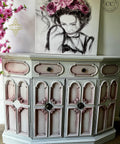 Oyster Silk All-In-One paint is perfect for painting kitchen cabinets, bathroom cabinets and painting furniture. White  Silk All-In-One painted side table with pink blended into the corners. Staged with a painting of a girl with pink flowers.