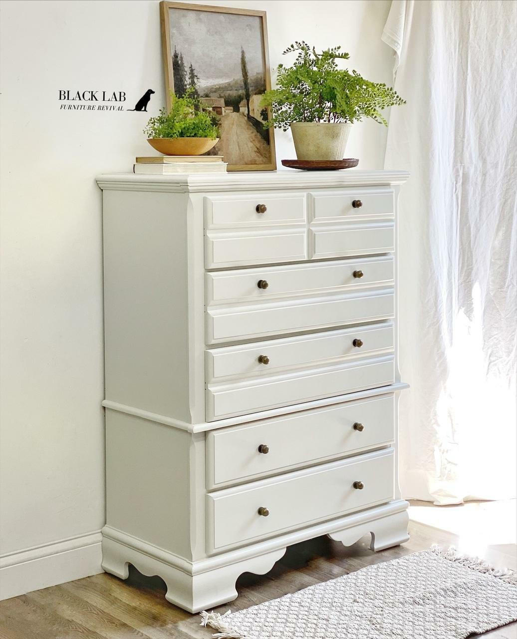 Oyster Silk All-In-One paint is perfect for painting kitchen cabinets, bathroom cabinets and painting furniture. White  Silk All-In-One painted dresser with bronze hardware. Staged with plants and a picture.