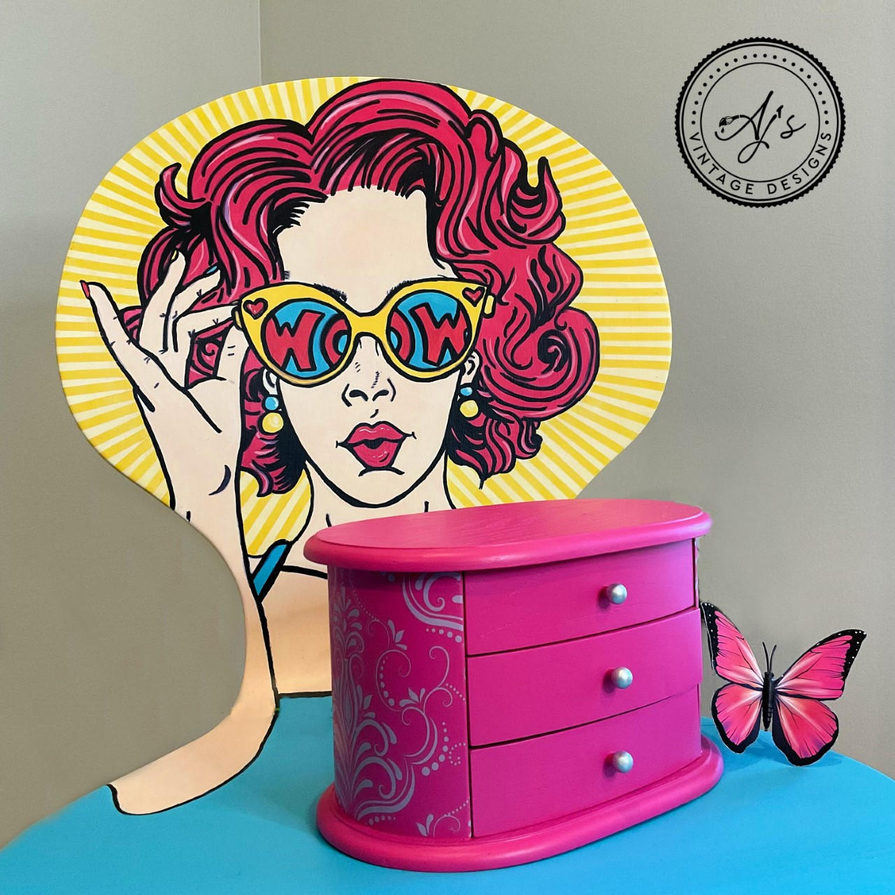 Prickly Pear Silk All-In-One paint is perfect for painting kitchen cabinets, bathroom cabinets and painting furniture. Pink chalk painted jewelry box with silver scroll detail painted on the side. Staged on a chair with a girl painted on in different colors.