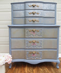 Quiet Cove Silk All-In-One paint is perfect for painting kitchen cabinets, bathroom cabinets and painting furniture! A vintage dresser with the top being slightly smaller than the body of the dresser but has 3 drawers on each level, 6 drawers in total. Featuring this medium-gray paint throughout the whole dresser and gold Victorian style hardware and cherry blossoms on the bottom 3 drawers.