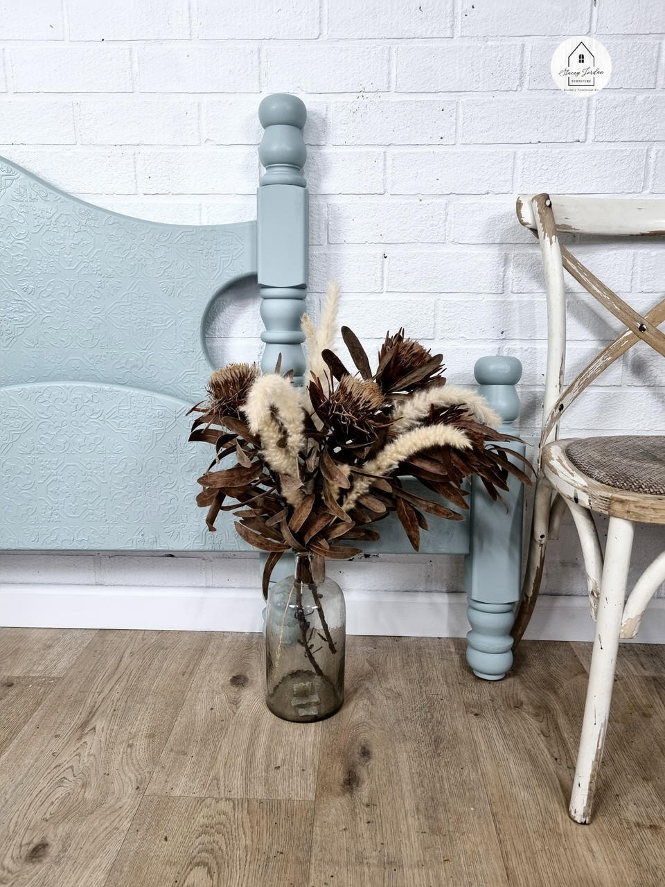 Serenity Silk All-In-One paint is perfect for painting kitchen cabinets, bathroom cabinets and painting furniture! A headboard and a baseboard painted in serenity and staged with greenery to the right.