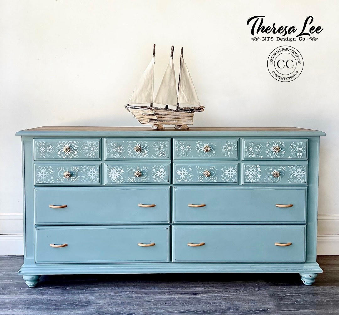 Serenity Silk All-In-One paint is perfect for painting kitchen cabinets, bathroom cabinets and painting furniture! A long dresser painted in serenity with a white stencil on the top drawers and silver hardware.