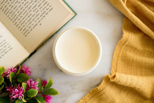 Sun Kissed Silk All-In-One paint is perfect for painting kitchen cabinets, bathroom cabinets and painting furniture.
Opened container of Sun Kissed Silk All-In-One Mineral Paint. Staged with an opened book,flower and a yellow linen.