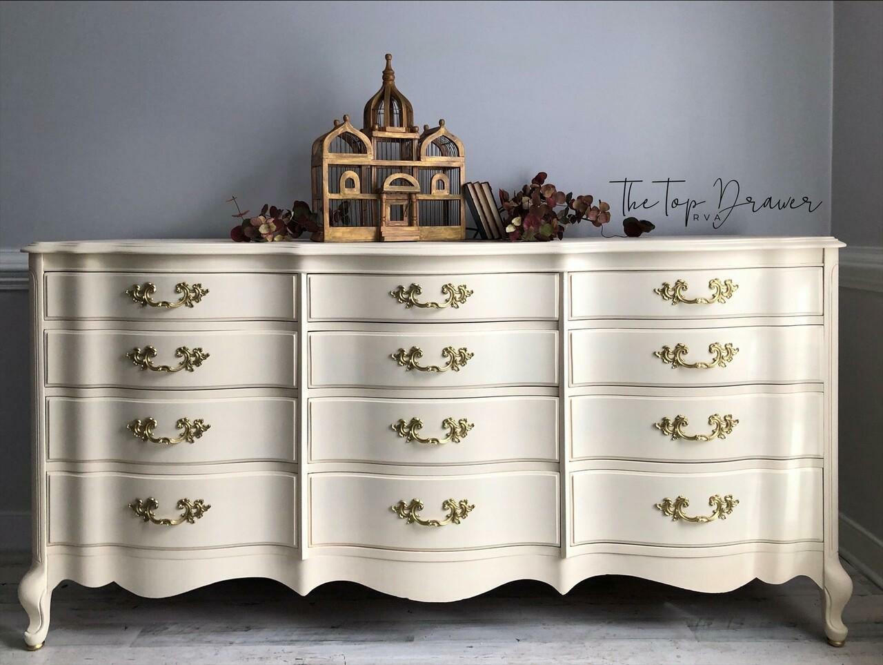 Sun Kissed Silk All-In-One paint is perfect for painting kitchen cabinets, bathroom cabinets and painting furniture.
Wide dresser painted all in Sun Kissed Silk All-In-One Mineral Paint with gold hardware staged with a wooden cage shaped as the Taj Mahal with brown leaves surrounding it.