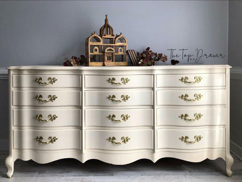Sun Kissed Silk All-In-One paint is perfect for painting kitchen cabinets, bathroom cabinets and painting furniture.
Wide dresser painted all in Sun Kissed Silk All-In-One Mineral Paint with gold hardware staged with a wooden cage shaped as the Taj Mahal with brown leaves surrounding it.