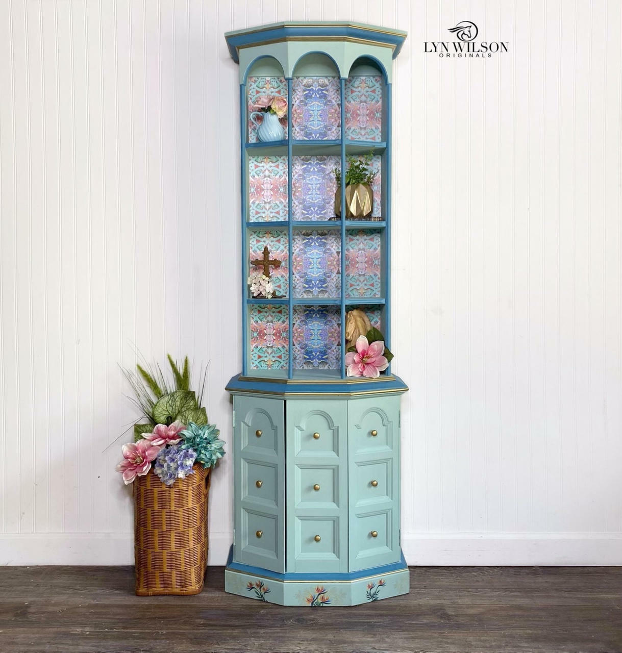 Tide Pool Silk All-In-One paint is perfect for painting kitchen cabinets, bathroom cabinets and painting furniture.  A blue chalk painted curio cabinet with dark blue chalk painted highlights and gold knobs.  Pink, purple, and blue patterned decoupage paper line the back of the shelves, and flower rub-on furniture transfers adorn the base.