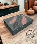 Bluish gray painted box makeover with hand-painted black and red fathers on top, along with a hand-painted string of blue and green beads on the feathers and around the rim of the box.