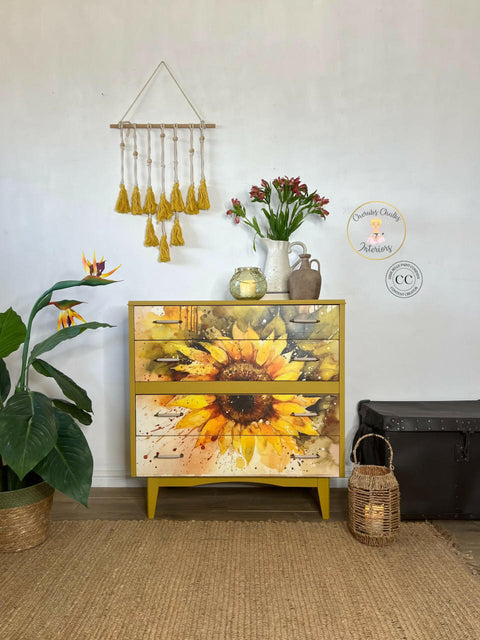 Cozy interior corner featuring a vibrant Sunny Daze A1 Rice Decoupage Paper-themed dresser, accompanied by a lush green plant, a vase with fresh flowers, and decorative items, creating a harmonious blend of nature-inspired decor and modern design.