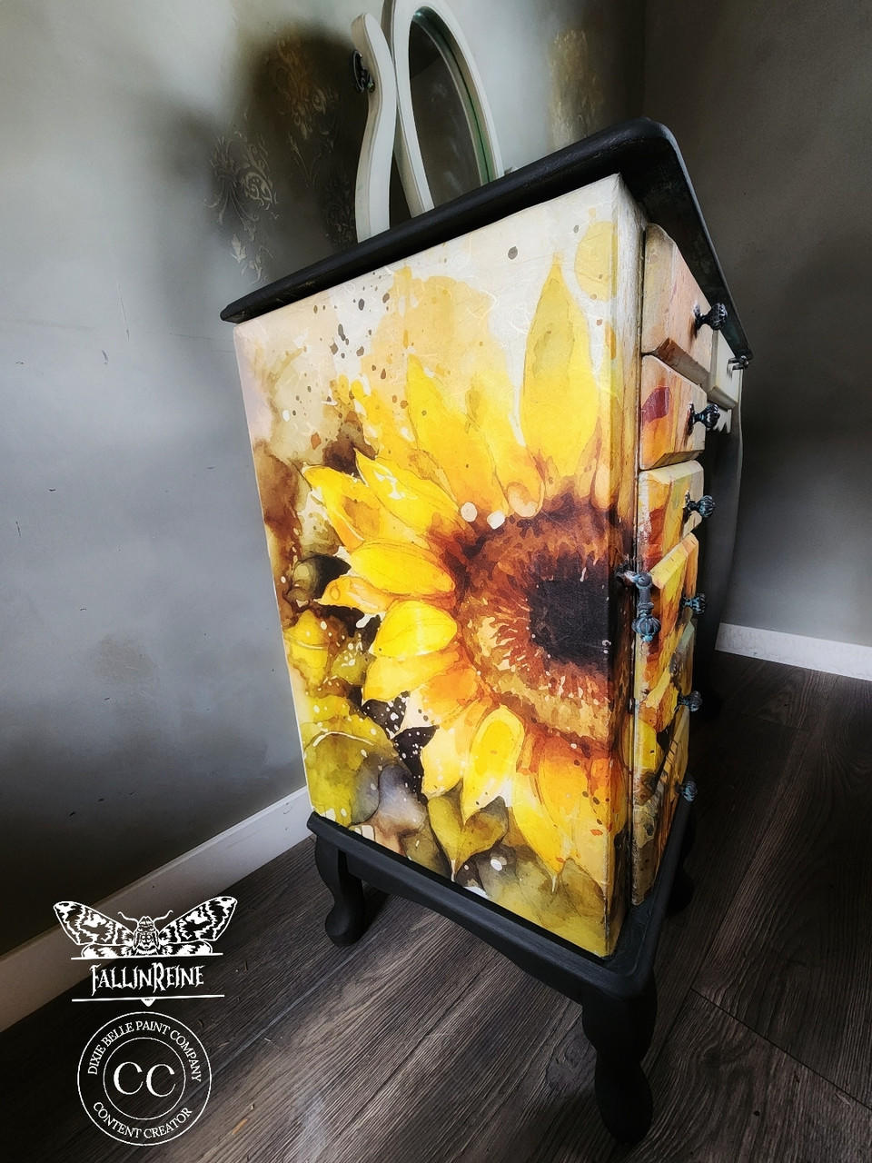 A vibrant and artistically painted dresser showcasing a bold Sunny Daze A1 Rice Decoupage Paper motif, set against a moody, dark background which accentuates the bright floral design.