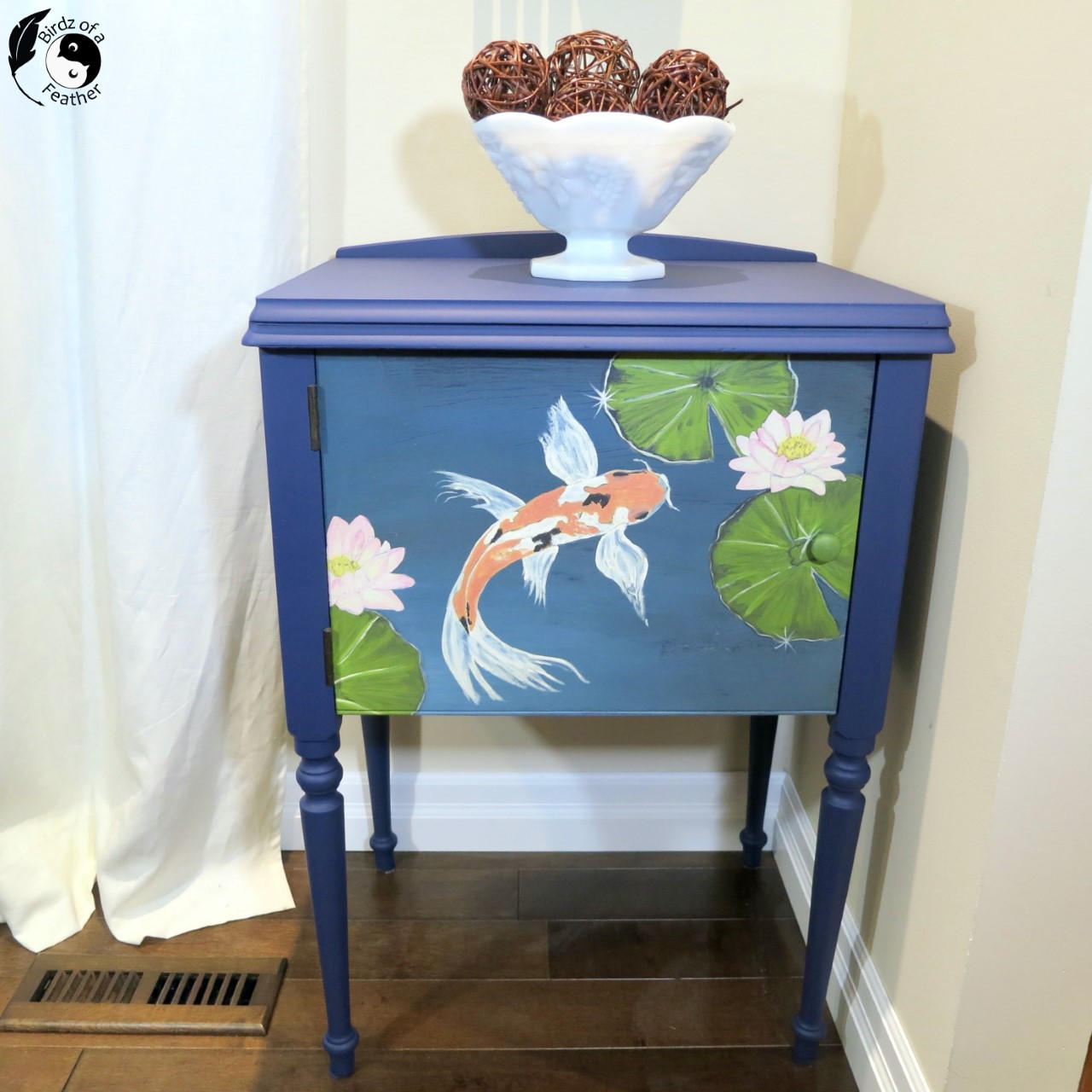 Blue Moon Terra Clay Paint provides endless possibilities for your imagination and can be used on wood, canvas, tile, fabric and more!
Beautiful end table using Blue Moon Terra Clay Paint as the base color with Balance - Transfer on the door panel.Staged with a white bowl and brown balls inside on top of piece.