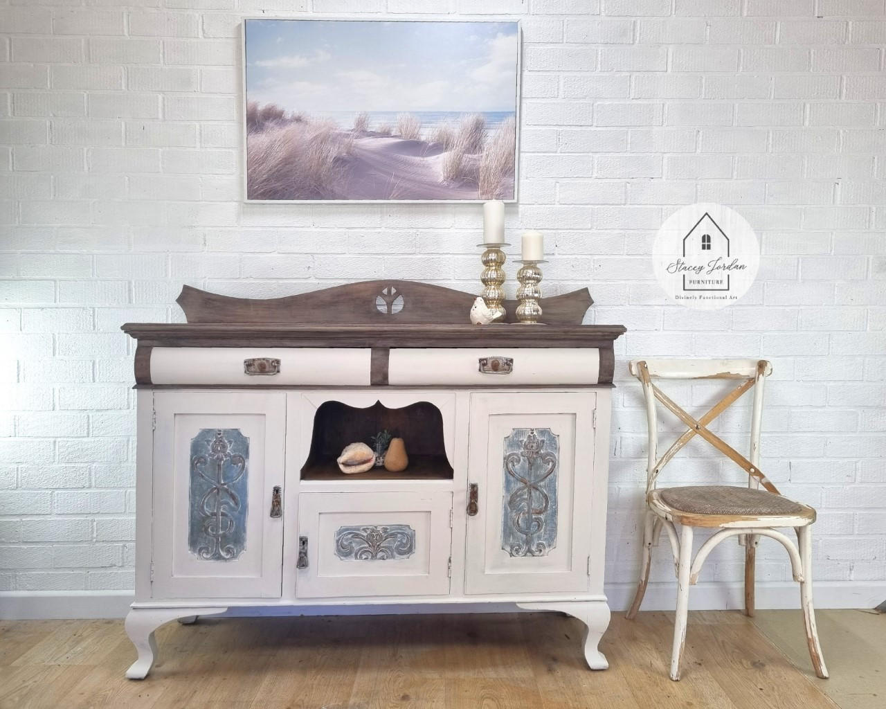 Blue Moon Terra Clay Paint provides endless possibilities for your imagination and can be used on wood, canvas, tile, fabric and more!
White Credenza with brown top and brown hardware. On door panels they have woodwork in the middle accentuated with Blue Moon Terra Clay Paint . Staged in  aroom with white brick wall and wood floors.