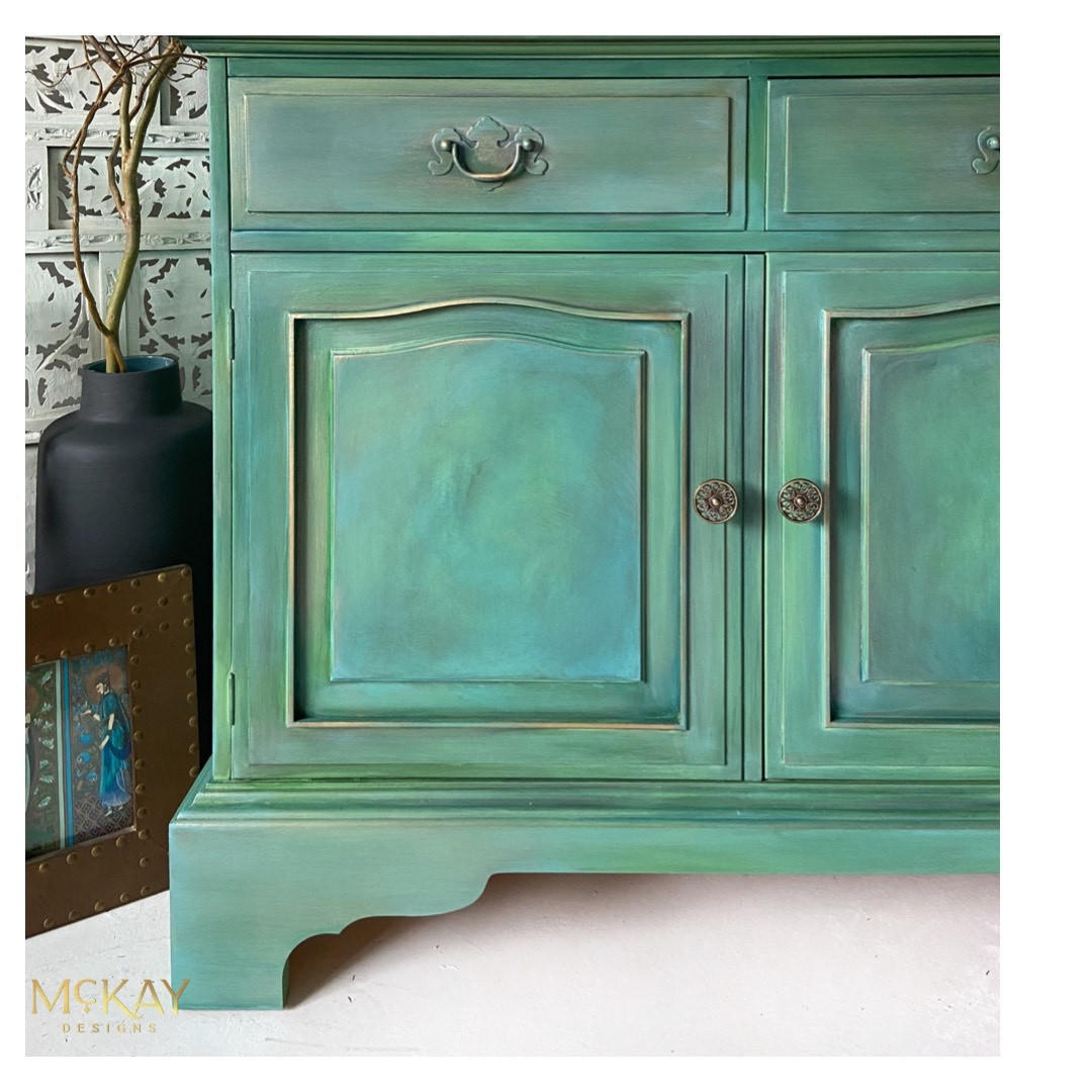 Blue Moon Terra Clay Paint provides endless possibilities for your imagination and can be used on wood, canvas, tile, fabric and more!
A green vanity with Blue Moon Terra Clay Paint and some gray to give it a smokey effect. Staged with black vase and bronze picture frame.