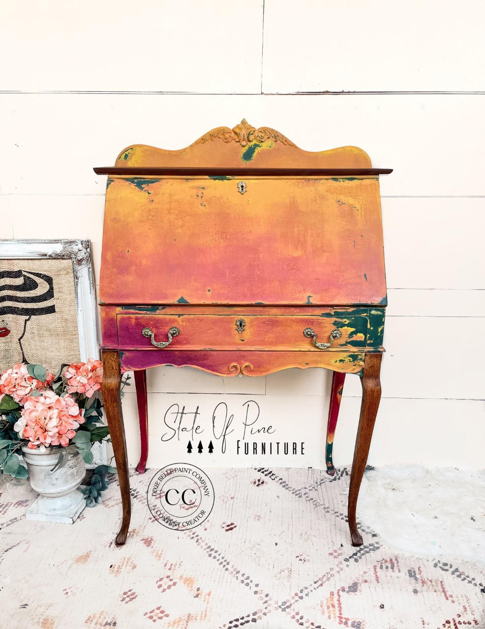Bougainvillea Terra Clay Paint provides endless possibilities for your imagination and can be used on wood, canvas, tile, fabric and more!
Secretary desk painted with Marigold, Daffodil & Bougainvillea Terra Clay Paint with Gold Gilding Waxing along the hardware. Staged along a white wall.