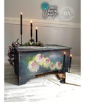 Bougainvillea Terra Clay Paint provides endless possibilities for your imagination and can be used on wood, canvas, tile, fabric and more!
Chest in a dark gray with hand painted white with hints of green and yellow flowers using Bougainvillea Terra Clay Paint as an accent inside flowers. Staged with tall black candles , faux flowers and books.
