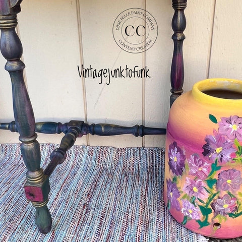 Desert Tan Terra Clay Paint provides endless possibilities for your imagination and can be used on wood, canvas, tile, fabric and more!
This picture shows a a couple spindly legs of a piece of furniture with a back and cross arm of the same ilk.  It is painted in blue's and pink's.  The piece of furniture rests on a multicolored, striped rug. There is a yellow and pink large jug next to the piece of furniture.  There are purple and pink flowers decoupaged on the jug.