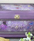 Elderberry Terra Clay Paint provides endless possibilities for your imagination and can be used on wood, canvas, tile, fabric and more! Purple clay painted jewelry chest with a gold lock. Wildflowers & Butterflies rub on furniture transfer applied on the chest. In the open space, the Botanical Silkscreen Stencil was applied using Chameleon Wax.