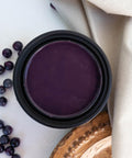 Elderberry Terra Clay Paint provides endless possibilities for your imagination and can be used on wood, canvas, tile, fabric and more! Open can of Elderberry Terra Clay Paint staged with berries and a white drop cloth.