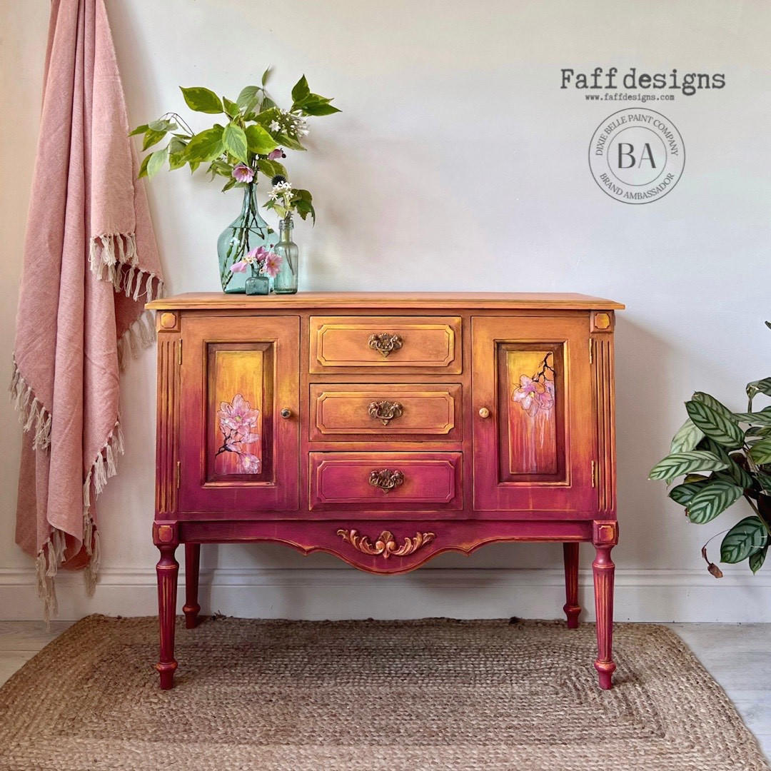 Marigold Terra Clay Paint provides endless possibilities for your imagination and can be used on wood, canvas, tile, fabric and more! Pink and orange Terra Clay painted Ombre Dresser with Floral Rub on transfers. Staged with glass vases and plants inside.