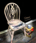 Moon Beam Terra Clay Paint provides endless possibilities for your imagination and can be used on wood, canvas, tile, fabric and more! Chair Painted cream with terra clay paint with Man in Gondola Decoupage paper. Staged next to a stack of books.