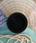 Onyx Terra Clay Paint provides endless possibilities for your imagination and can be used on wood, canvas, tile, fabric and more! Black clay paint open top view staged with lavender, wicker place mat and a wood beads.