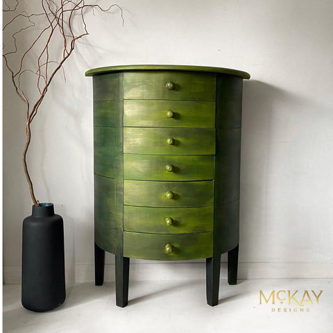Pistachio Terra Clay Paint provides endless possibilities for your imagination and can be used on wood, canvas, tile, fabric and more! Light green and dark clay painted and blended end table staged next to a black vase with a stick inside.